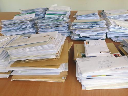 75.000 Unterschriften sind bereits für die Aktion „Gesundheit statt Schulden“ eingegangen (Foto: Weltgebetstag e. V.). Stapelweise Unterschriftenlisten